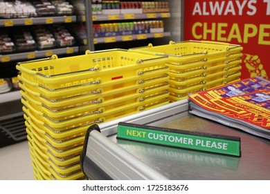 Dubai, United Arab Emirates - February 10, 2020: Checkout Counter Sign For Customers In A Supermarket, With Yellow Plastic Shopping Baskets In The Background.