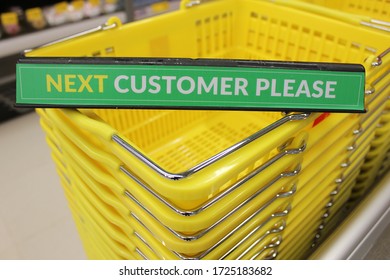 Dubai, United Arab Emirates - February 10, 2020: Checkout Counter Sign For Customers In A Supermarket, With Yellow Plastic Shopping Baskets In The Background.