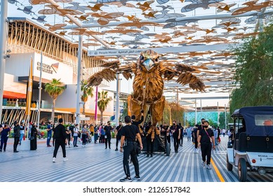 Dubai, United Arab Emirates - February 14, 2022: Expo 2020 Dubai, footpath with bird shaped sunshade roof and people walking, Saudi Arabia Pavilion in the background.