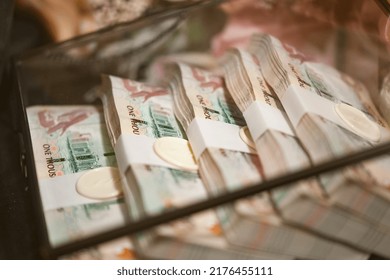 Dubai, United Arab Emirates - January 6, 2020: five bundles of one thousand United Arab Emirates Dirhams, in a glass box, as part of an Emirati groom's generous Mahr (dowry) for his soon-to-be bride.