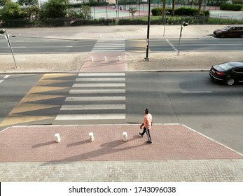 Dubai, United Arab Emirates - May 28, 2020: A man wearing a face mask walks to a pedestrian crossing/crosswalk in the city during the novel coronavirus (COVID-19) pandemic. - Shutterstock ID 1743096038