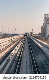 Dubai, United Arab Emirates - November 06, 2021: Dubai Metro Train On Rails At Background Of Skyscrapers. Famous Outdoor Subway Red Line