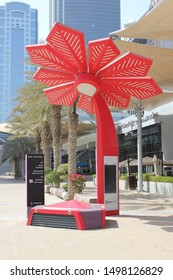 Dubai, United Arab Emirates - September 7, 2019: A red 'Smart Palm' tree provides free WiFi, NFC and digital advertising opportunities near Dubai World Trade Centre halls and convention centre.