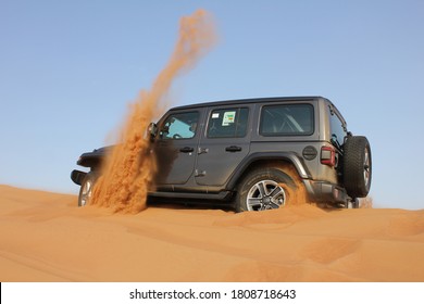 Dubai, United Arab Emirates - September 4, 2020: Jeep Wrangler 4x4/4WD driving off-road in arid desert sand dunes terrain. Dune bashing is a popular adventure sport activity in the Arab country.