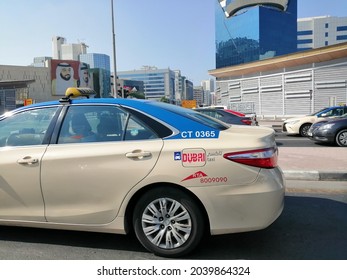 Dubai, United Arab Emirates - September 11, 2021: Dubai taxi on a city road displays Dubai Roads and Transport Authority (Dubai RTA) logo on its side panel.