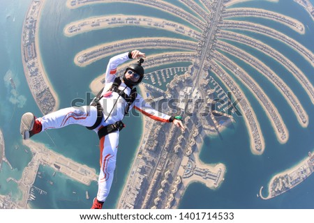 Dubai.People lies on beach Dubai Palm in free fall sky jump. Sea outdoor skydiving travel man. Free fall extreme action sky man on speed 200.  Summer fly beach sky man advertising business. Background