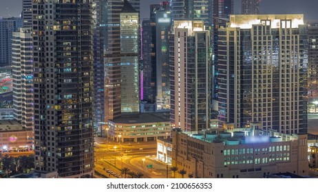 Dubai's Business Bay Office And Recidential Towers Aerial Night Timelapse. Rooftop View Of Some Skyscrapers And Traffic On Intersection