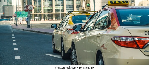 Dubai,UAE - April 02, 2021: The official RTA taxis of Dubai with all the easily recognizable colored car red roof parked on road side in Business Bay