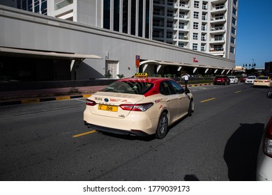 Dubai,UAEmirates - Juli 18, 2020: The official RTA and cheaper state taxi of Dubai with all the easily recognizable colored car red roof