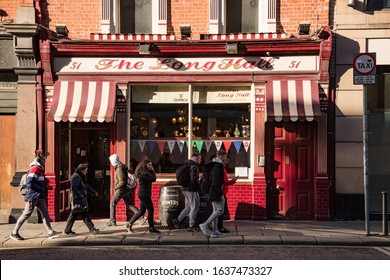 Dublin, Ireland - 29th January 2020: People Walking By The Long Hall Pub In South Great Georges Street, One Of Dublins Oldest Pubs Dating Its History Back To 1766.