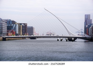 DUBLIN, IRELAND - APRIL 23, 2022: City Landscape With Iconic Samuel Beckett Bridge By Santiago Calatrava On The River Liffey In Dublin Docklands. Modern And Elegant Cable-stayed Harp-shaped Bridge.