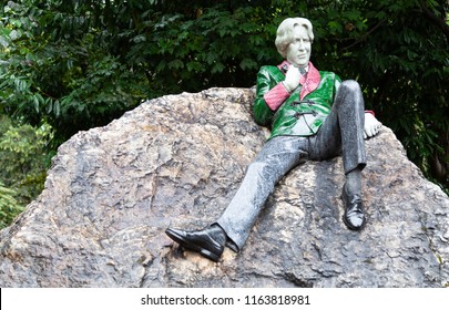 Dublin, Ireland August 17, 2018: Sculpture of writer Oscar Wilde in Merrion Square. The artwork by Danny Osborne was unveiled in 1997. The art shows Wilde reclining on a large boulder.