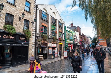 Dublin, Ireland - December 08, 2018: People Strolling Along A Cobbled Street Lined With Pubs And Restaurants In Temple Bar, A Busy Riverside Neighbourhood, Spread Over Cobbled Pedestrian Lanes.