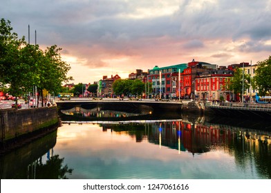 Dublin, Ireland. Embankment of Liffey River in Dublin, Ireland. Sunset view with buildings and city lights at the background.