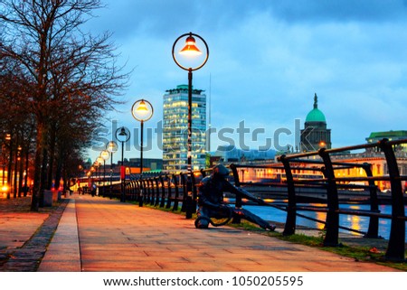 Dublin, Ireland. Illuminated Sean O'Casey Bridge with the Custom House in Dublin, Ireland at night. Cloudy blue sky