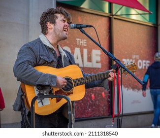 Dublin, Ireland - January 14 2022

Tipperary singer and musician Dáwna busks outside Brown Thomas on Grafton Street to people passing by, as they celebrate easing of restrictions, and January sales