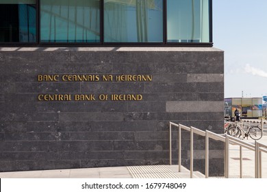 Dublin / Ireland - March 2020 : Architectural Elements Of Central Bank Of Ireland Building Located On North Wall Quay Along Liffey River.  Entrance Door With Central Bank Sign In English And Irish