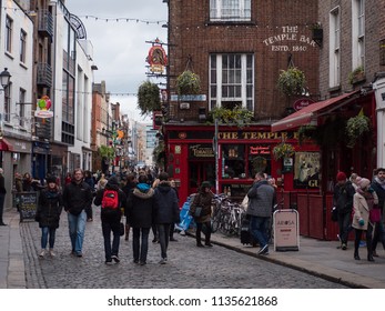 Dublin, Ireland - March 6th 2016: Tourists And Visitors Walk On Cobbled Street Past Colorful Irish Pubs In The Temple Bar Area Of Dublin City.