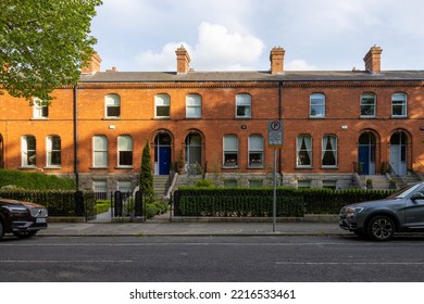 DUBLIN, IRELAND - May 19, 2022: A Brick Building In Dublin Ireland In A Neighborhood With Parked Cars And Vegetation