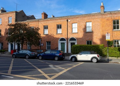 DUBLIN, IRELAND - May 19, 2022: A Brick Building In Dublin Ireland In A Neighborhood With Parked Cars And Vegetation