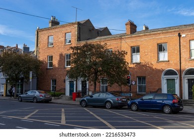 DUBLIN, IRELAND - May 19, 2022: A Brick Building In Dublin Ireland In A Neighborhood With Parked Cars And Vegetation