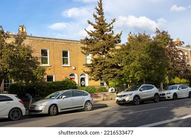 DUBLIN, IRELAND - May 19, 2022: A Brick Building In Dublin Ireland In A Neighborhood With Parked Cars And Vegetation