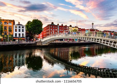 Dublin, Irland. Nachtblick auf die berühmte Ha Penny Bridge in Dublin, Irland bei Sonnenuntergang