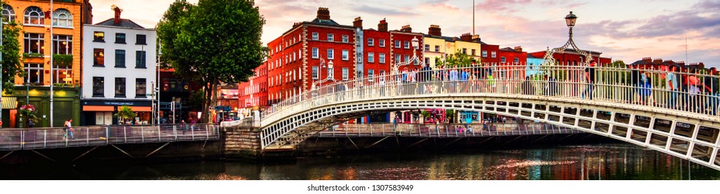  Dublin, Irland. Nachtblick auf die berühmte Ha Penny Bridge in Dublin, Irland bei Sonnenuntergang