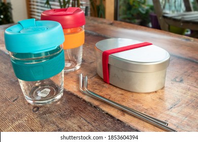 Dublin, Ireland - November 11th 2020: Two Reusable Eco Friendly Glass Keep Cups, A Metal Bento Lunchbox And Stainless Steel Metal Straws In A Café. Eco Friendly Zero Waste Sustainable Living Supplies 