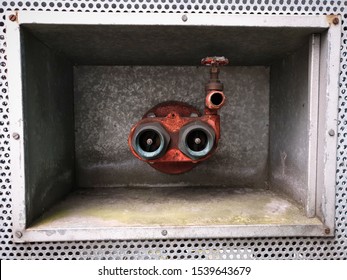 DUBLIN, IRELAND - OCTOBER 19, 2019: Fire Extinguisher Heads With Water Valve Mounted Inside Box In The Wall That Looks Like Scuba Diver's Face Or Cute Monster. Accidental Art.