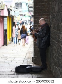 Dublin, July 3rd 2021

A Busker Performs In The Arch Of Merchant's Arch, Temple Bar, Dublin. Stood Playing His Guitar In The Hopes Of A Tip In His Guitar Case, Seen In Front Of Him. 