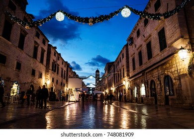 DUBROVNIK, CROATIA - December 31 2015: Stradun Old Street Decorated With Christmas Lights And Ornaments In The Night With Poeple Walking Around