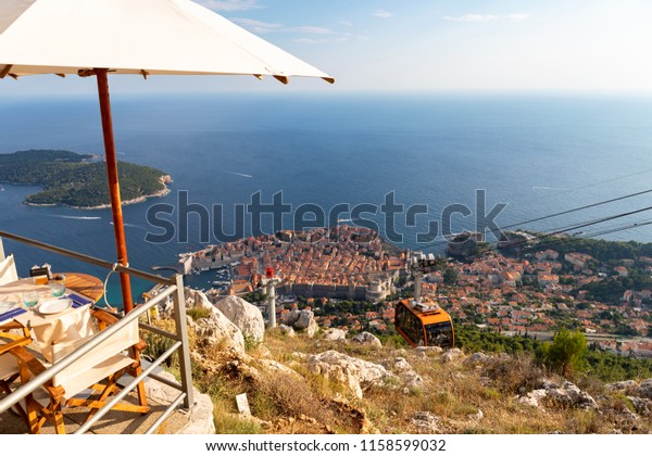 Dubrovnik Old Town from above. Cable Car.\
Restaurant with Table. Dinner with a\
view.