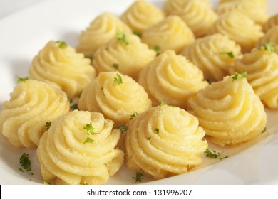 Duchess potatoes, mashed potato mixed with egg, piped into swirls and baked in the oven. - Shutterstock ID 131996207