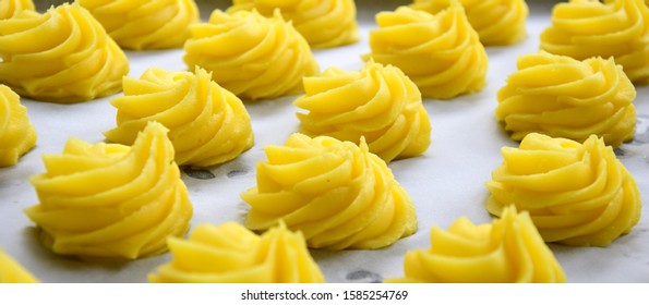Duchess potatoes raw on a tin - Shutterstock ID 1585254769