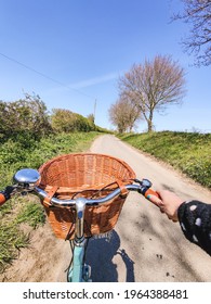 A Duck Egg Blue Classic Bicycle With A Wicker Basket On A Tree Lined Country Lane In Rural Britain In Spring
