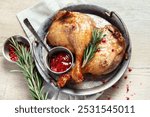 Duck leg confit with sauce on a wooden. background. Traditional French cuisine. Top view.