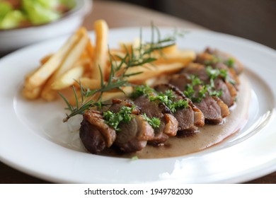 Duck magret confit with chips on wood table