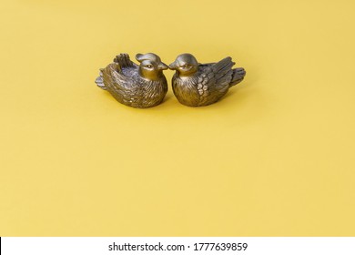 Сopper Ducks Figurines On Yellow Background Symbol Of Love And Fidelity In Feng Shui. Selective Focus. Copy Space