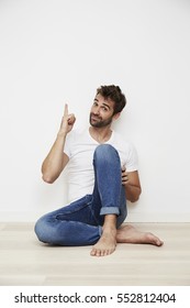 Dude sitting on floor and pointing up, portrait