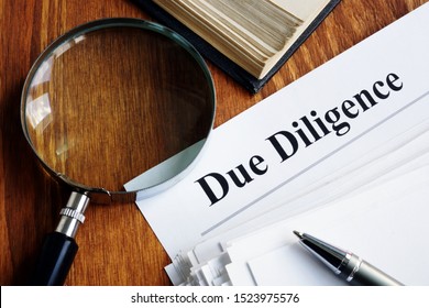 Due Diligence concept. Stack of documents and magnifying glass. - Shutterstock ID 1523975576