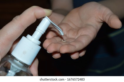 Due to the new corona virus (covid 19) people are washing their hands or using hand sanitizer several times a day. Close up image of mother helping child use hand sanitizer . - Shutterstock ID 1676572483