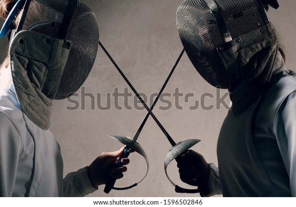 Duel of fencers with fencing sword. Fencers\
dueling concept.