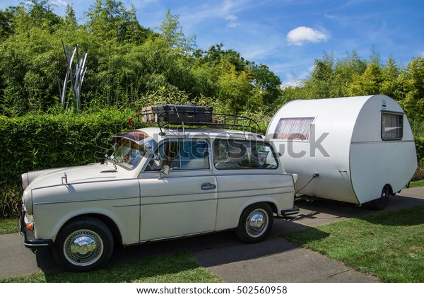 DUESSELDORF, GERMANY - AUGUST 2015: TINY CAR WITH\
VINTAGE CAMPING TRAILER IN THE\
PARK
