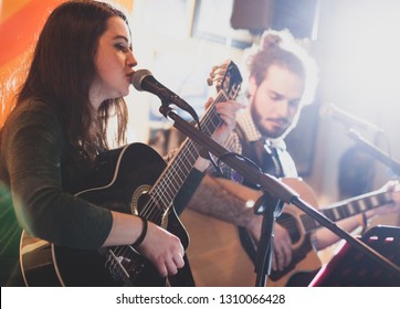 Duet Of Guitarists Singing During A Musical Performance. Backlight With Flare.