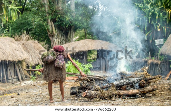 デュガム谷族の村 ドゥグム ダニ族の女性は 豚をイヤートーベンで調理し 食べ物を調理する 西パプア ニューギニア島 の写真素材 今すぐ編集
