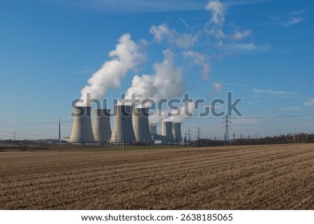 Dukovany Nuclear Power Plant in the Czech Republic, Europe. Smoke cooling towers. There are clouds in the sky. In the background the nature of the Highlands.