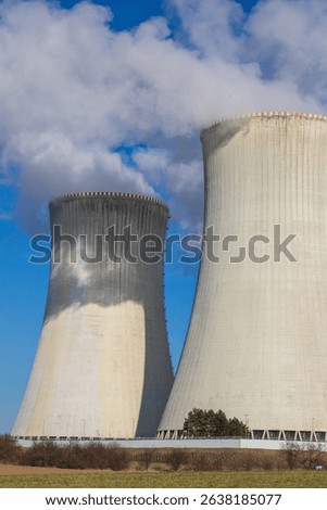 Dukovany Nuclear Power Plant in the Czech Republic, Europe. Smoke cooling towers. There are clouds in the sky. In the background the nature of the Highlands.