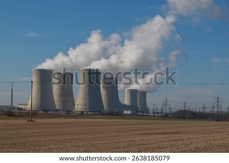Dukovany Nuclear Power Plant in the Czech Republic, Europe. Smoke cooling towers. There are clouds in the sky. In the background the nature of the Highlands.