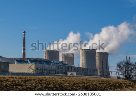 Dukovany Nuclear Power Plant in the Czech Republic, Europe. Smoke cooling towers. There are clouds in the sky. In the background the nature of the Highlands.